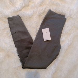 Grey Nike leggings with mid rise, tight fit, and full length.